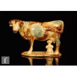 An early 19th Century cow creamer with a milk maid and pail beneath, she decorated with blue green