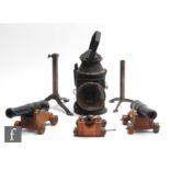 A hand held signal lamp, an adjustable trivet and three cast iron fire side canons with