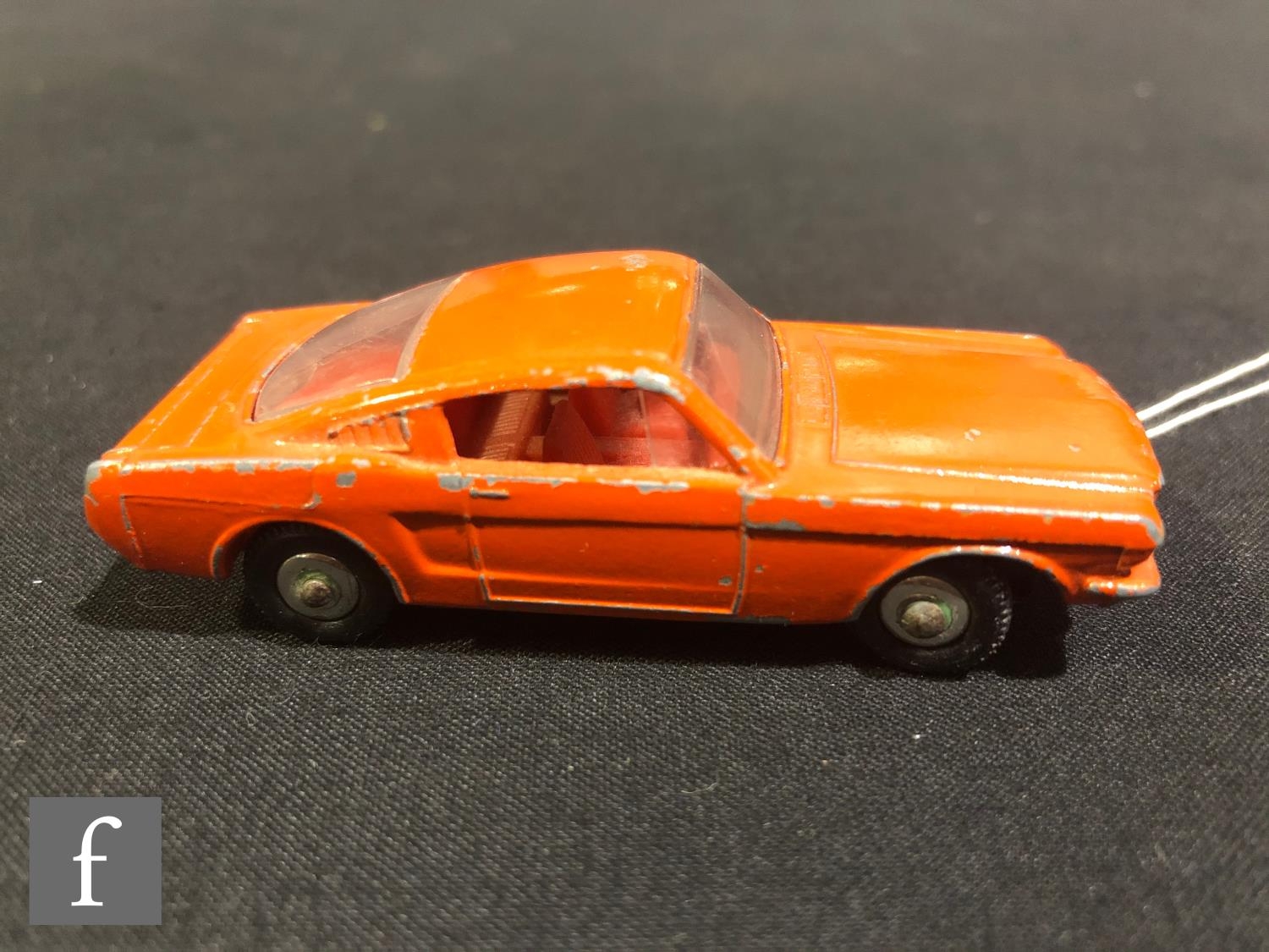 A Matchbox Regular Wheels 8e Ford Mustang diecast model car, in burnt orange with red interior clear