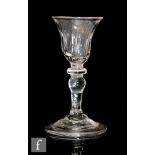 An 18th Century balustroid gin glass circa 1740, the fluted bell form bowl above a compressed