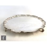 A hallmarked silver circular salver of plain form terminating in scalloped stepped border and raised