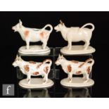 Four assorted 19th Century Staffordshire cow creamers and covers comprising two with brown sponged