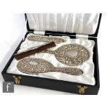 A cased hallmarked silver backed brush set comprising hand mirror, two brushes and a comb, each with