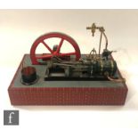 A single horizontal cylinder engine with governor and six spoked flywheel painted in red with