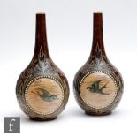 A mirrored pair of late 19th Century Doulton Lambeth bottle vases decorated by Florence Barlow and