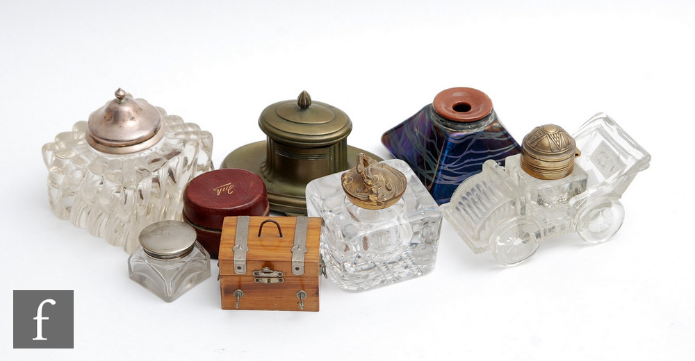 A collection of assorted ink wells of varying forms to include one modelled as a vintage car, one