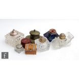 A collection of assorted ink wells of varying forms to include one modelled as a vintage car, one