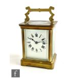 A 20th Century brass carriage clock, white enamelled dial on stepped base, height 10cm.
