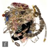 A large parcel lot of assorted costume jewellery to include beads, brooches, bangles, bracelets,