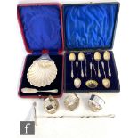 A cased set of six apostle spoons with conforming tongs and caster spoon, a cased shell shaped