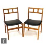 A set of six 1970s teak dining chairs, with pierced rail backs over black vinyl upholstered