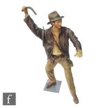A life size painted fibre glass mannequin of Indiana Jones dressed in the classic outfit with hat,