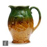 An early 20th Century water jug decorated with a relief moulded scene of a running footballer to one