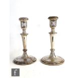 A pair of hallmarked silver candlesticks, circular stepped bases below plain flaring columns and