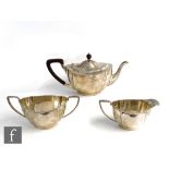 A hallmarked silver boat shaped and cushioned faceted three piece tea set terminating in angular