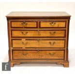 A George III oak and mahogany crossbanded chest of two short and three long drawers, brass drop