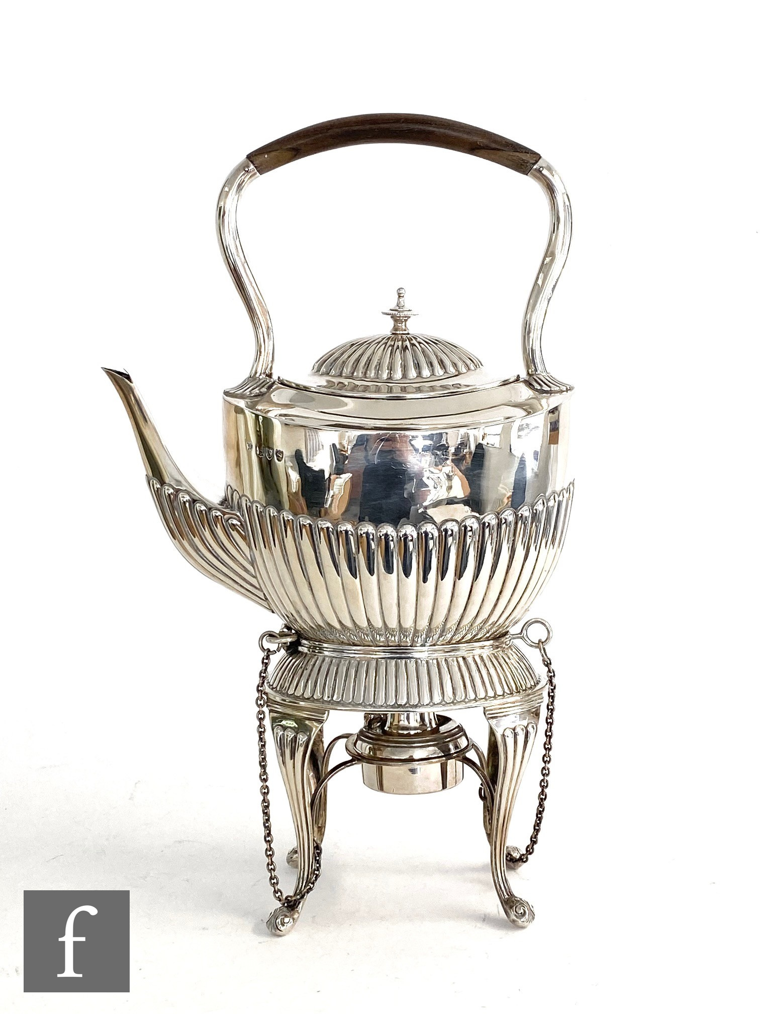 A hallmarked silver boat shaped spirit kettle and stand with part fluted decoration and raised on