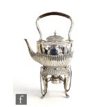 A hallmarked silver boat shaped spirit kettle and stand with part fluted decoration and raised on