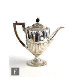 A hallmarked silver boat shaped pedestal coffee pot with part fluted decoration, terminating in