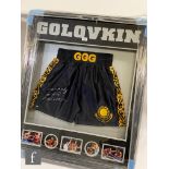 A framed pair of GGG dark blue boxing shorts signed by Golovkin, above action inset photographs to