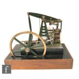 A live steam beam engine with single wood lagged cylinder and six spoked flywheel, painted in