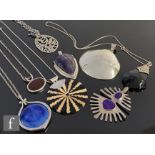 Eight assorted silver and white metal mounted pendants to include a blue Ruskin and an amethyst