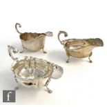 Three hallmarked silver sauce boats, each raised on three stepped pad feet and terminating in flying