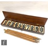 An early set of 20th Century cricket score numbers contained in a hinged wooden box and a set of