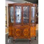 A Queen Anne style walnut display cabinet enclosed by a bar glazed door over a cupboard base on