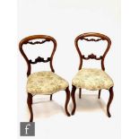 A set of four Victorian mahogany salon chairs, carved scroll splats, on cabriole legs, upholstered