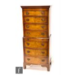 A 20th Century Queen Anne style walnut bow front chest on chest fitted with seven drawers centred by