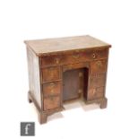 An 18th Century crossbanded and inlaid kneehole writing desk, the quartered and detailed inlaid