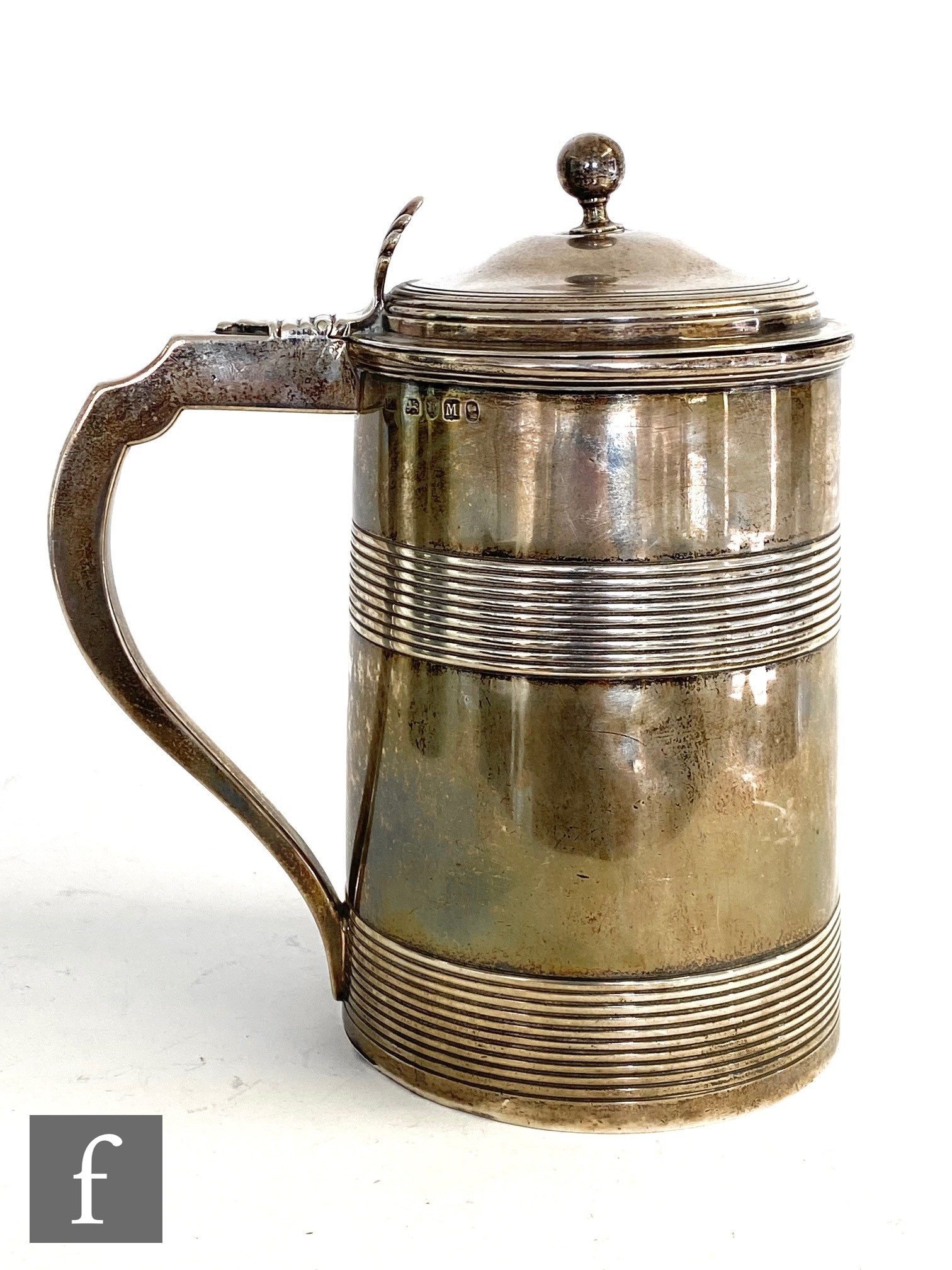 A George III hallmarked silver cylindrical tankard detailed with two reeded bands, scroll handle