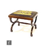 An Edwardian mahogany stool with tapestry slip in top on swept cross end supports united by a turned