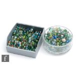 A large collection of glass marbles, mostly swirl examples, most with pontil marks and bubbles, of