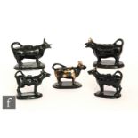 Five late 19th Century Jackfield cow creamers, each beast raised to an oval base, all with gilt