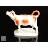 An early 20th Century Royal Dux cow creamer and cover, the cow with brown sponged patches, stood