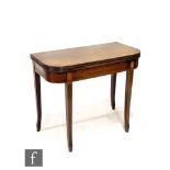 A George IV mahogany fold-over tea table, with a reeded edge above a plain apron and raised to