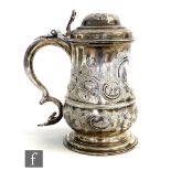 A George II hallmarked silver baluster tankard terminating in scroll handle and with later