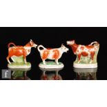 Two late 19th Century cow creamers and covers, both with brown sponged decoration, largest height