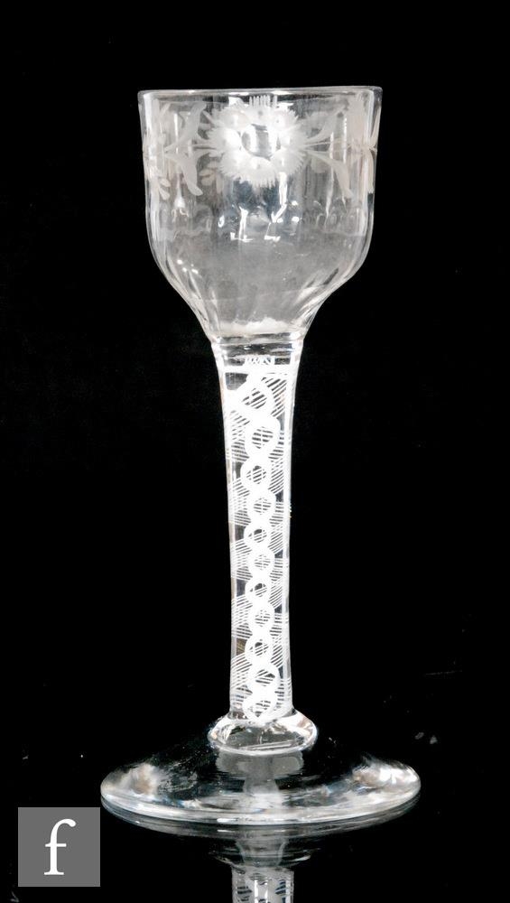 An 18th Century drinking glass circa 1765, the ogee bowl engraved with a floral border and with