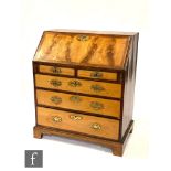 A George III mahogany bureau, the fitted drawer interior centred by a cupboard door flanked by two