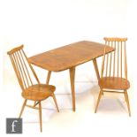 An Ercol light elm and beech table and chairs to include a set of four model 369 Goldsmith Windsor