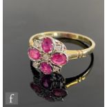 An 18ct hallmarked ruby and diamond cluster ring, four oval rubies radiating from a central