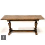 A 20th Century oak reproduction refectory style dining table with a triple plank top above twin