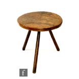 A rustic elm cricket table raised to splayed oak legs, height 53cm and diameter 53cm, S/D.
