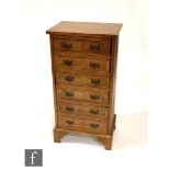 A reproduction walnut veneered and cross-banded chest of six drawers, raised to bracket feet, height