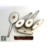 A hallmarked silver and enamel decorated five piece hair brush set comprising a hand mirror and four