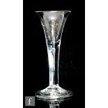A large 18th Century drinking glass circa 1750, the trumpet bowl above a teared plain stem, raised