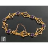 An early 20th Century 9ct rose gold fancy link bracelet detailed with six millgrain set amethyst,